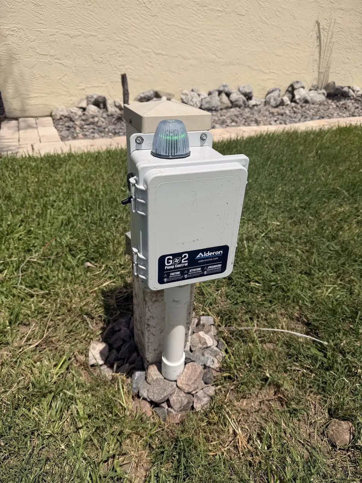 Alderon G2 lift station pump control and alarm panel mounted on a post in a yard